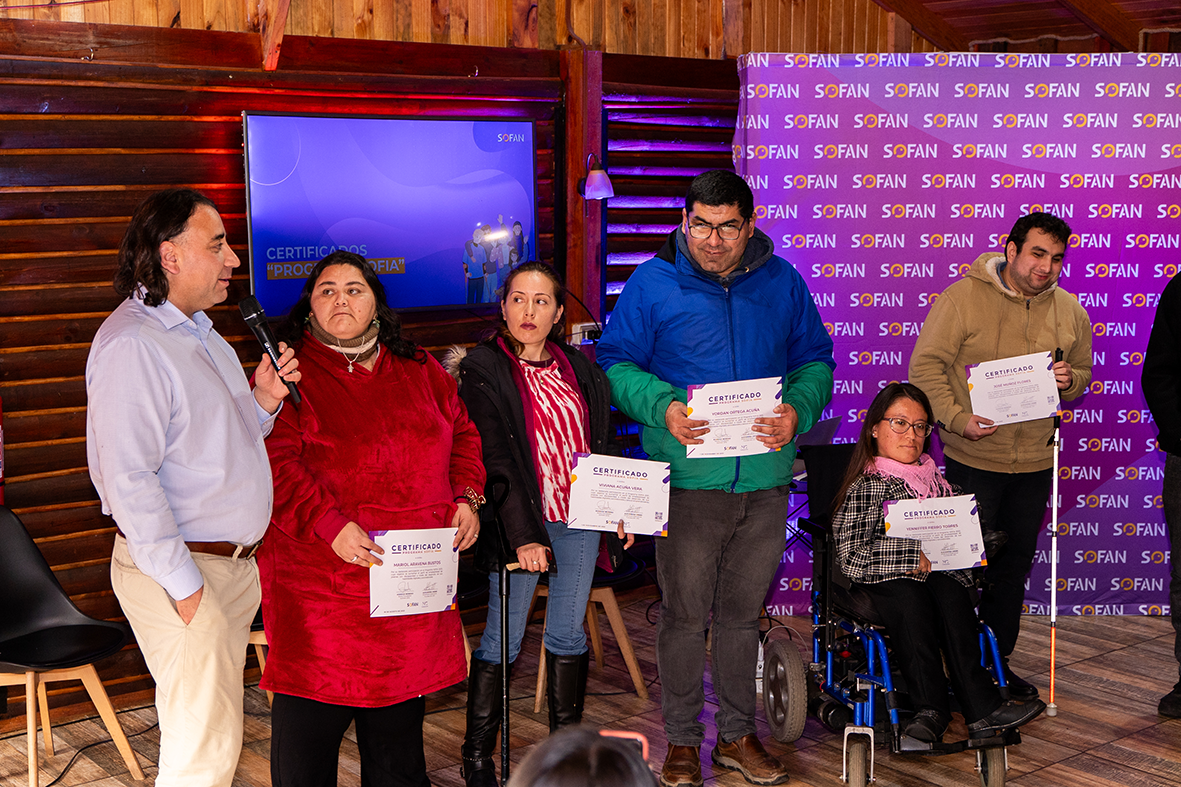 Rodrigo Moreno habla en el escenario junto a beneficiarios del Programa SOFÍA que recibieron sus certificados.